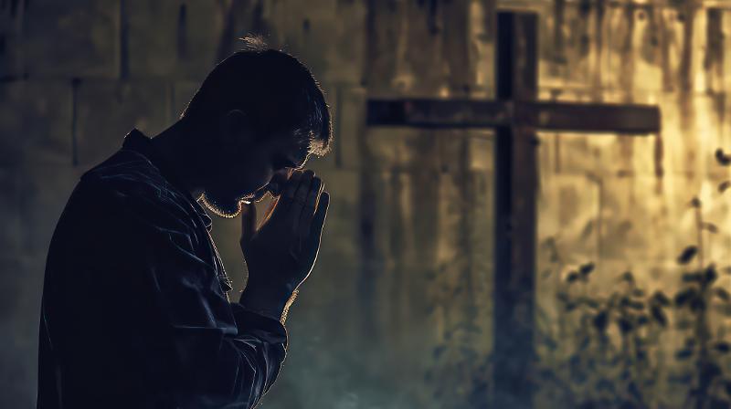 Man praying in front of a cross with copy space. Man praying in front of a cross with copy space